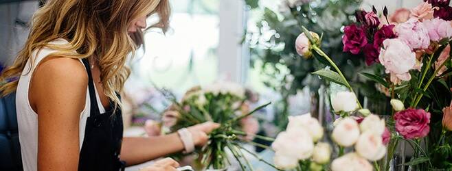 Woman cutting flowers in small business for progressive commercial insurance review